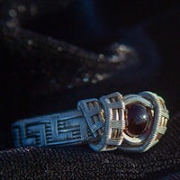 a silver ring with a garnet stone on it