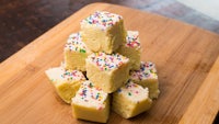 a stack of squares of fudge with sprinkles on top