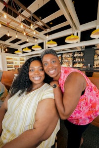 two women posing for a photo in a restaurant