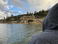 a person in a hoodie looking out over a body of water