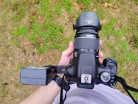 a person holding a camera with a lens attached to it