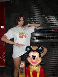 a woman posing next to a mickey mouse statue