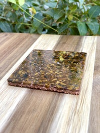 a brown and gold coaster sitting on top of a wooden table