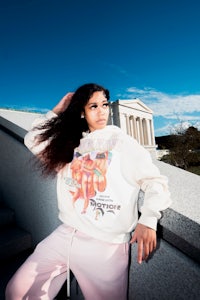 a woman wearing a pink hoodie posing in front of the lincoln memorial