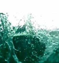 a close up of a green water splash