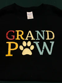 a black t - shirt with the word grand paw on it