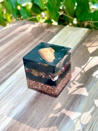 a square box with a black and gold design on it
