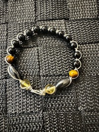 a black and yellow bracelet with tiger eye beads