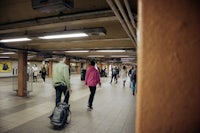 a group of people walking through a subway station
