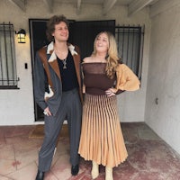 a man and a woman standing in front of a house