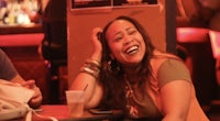 a woman and a man laughing at a bar