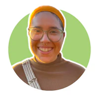 a smiling woman wearing glasses and a turban