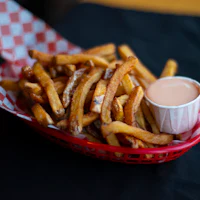 a basket filled with french fries and dipping sauce