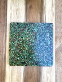 a green stone coaster on top of a wooden cutting board