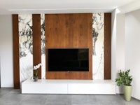 a living room with marble wall panels and a tv