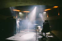a man is playing drums in a dark room