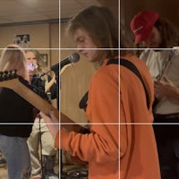 a group of people playing guitar in a room
