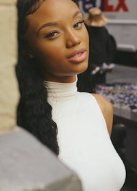 a young woman in a white top posing for a photo
