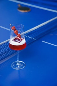 a glass of beer sitting on a blue table