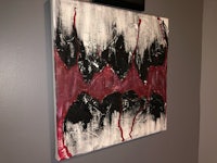 a black and red painting hanging on a wall