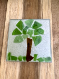 a green glass tree on a wooden surface