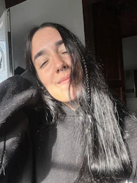 a woman with long black hair and a smile on her face