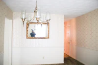 a hallway with a chandelier and a mirror