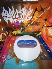 a skateboard is sitting on a table in a room covered in graffiti