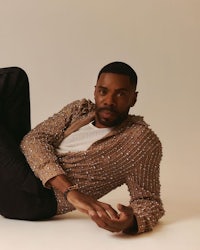 a black man laying on the floor in a beige shirt
