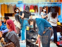 a group of people in a hair salon with masks on