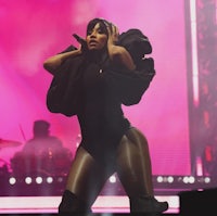 a woman in a black outfit performing on stage
