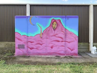 a pink wall with a painting of a woman on it