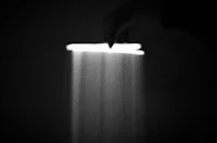 a black and white photo of a candle in a dark room