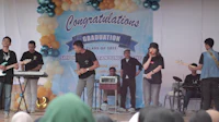 a group of people standing on stage in front of a banner