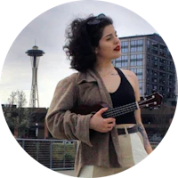a woman holding a ukule in front of the seattle skyline