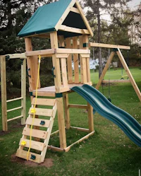 a wooden play set with a slide and swings