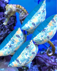 a seahorse is sitting on a blue pillow in an aquarium