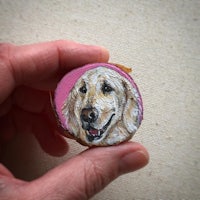 a person holding a piece of wood with a portrait of a golden retriever