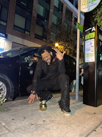 a man kneeling on the ground next to a parking meter
