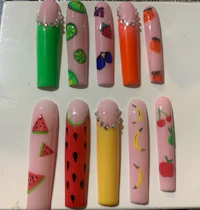 a set of nail art with fruit designs on them