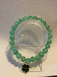 a green bracelet with a clover on it