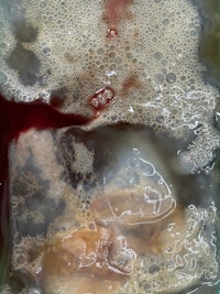 a close up of a liquid with blood on it