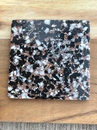 a black and white marble coaster on a wooden table