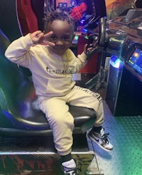 a young boy sitting on a machine in an arcade