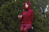 a woman in a red dress sitting on a bench