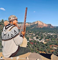 a man sitting on a ledge with a guitar