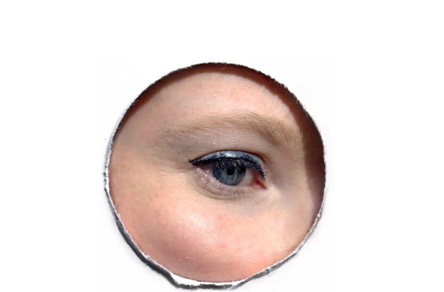 a woman's eye is shown through a piece of paper