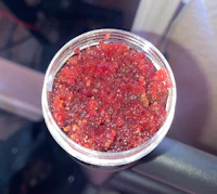 a jar of red gummy bears sitting on the seat of a car