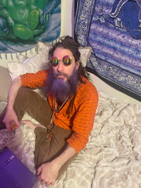 a man laying on a bed with a laptop
