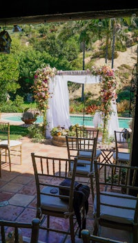 a wedding ceremony set up in front of a pool